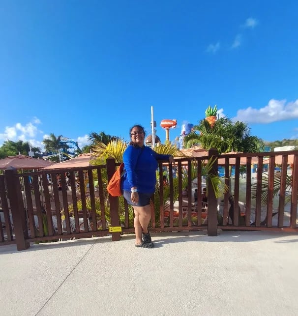 Persona en terraza tropical con plantas y cielo azul
