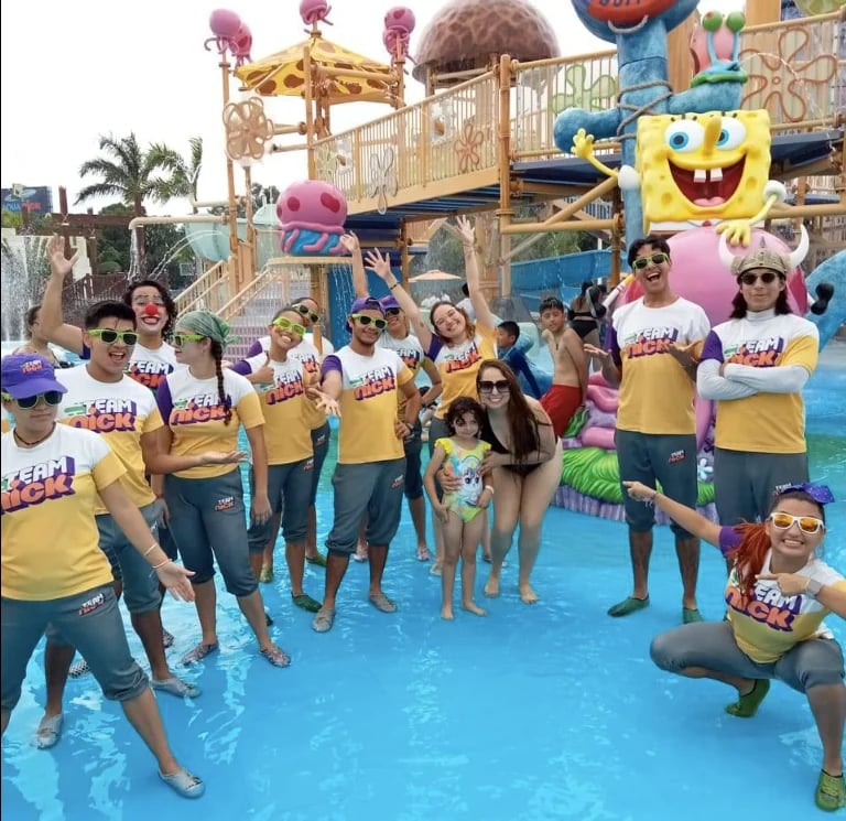 Grupo en agua con personaje de Bob Esponja en parque temático