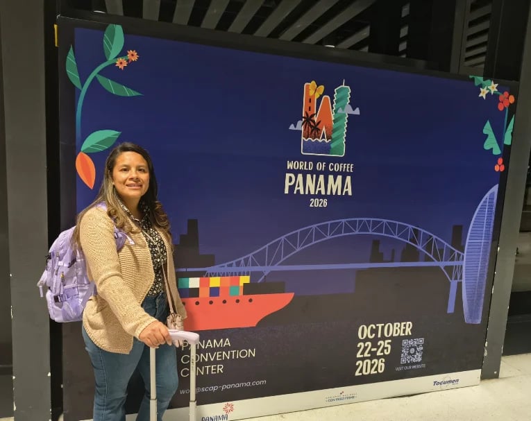 Viri Becerril en Colombia frente al poster Panama World of Coffee