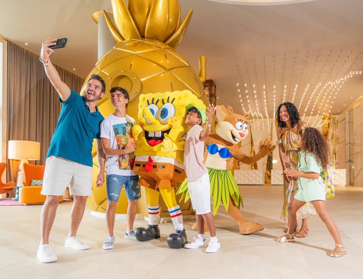 Familia posando feliz con el personaje de Bob Esponja en una suite del Hotel Nickelodeon