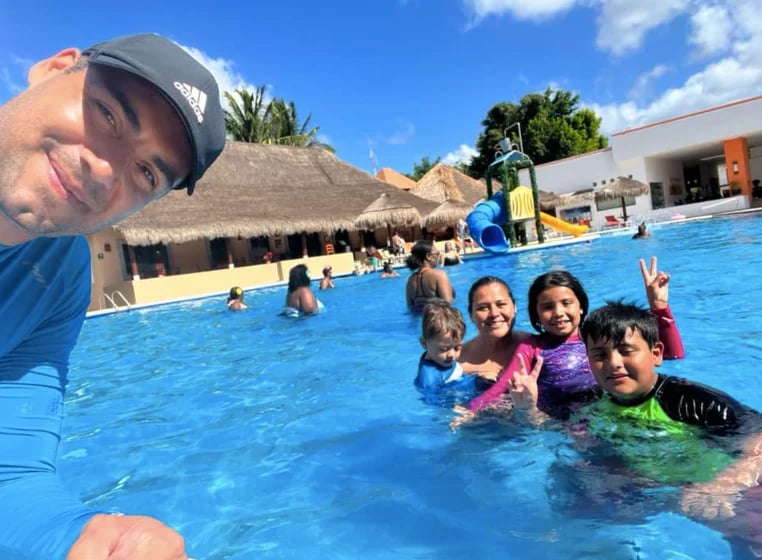 Familia y amigos disfrutando un día soleado en una piscina tropical